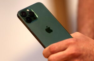 A customers holds the new green colour Apple iPhone 13 pro